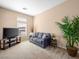 Comfortable living room with neutral walls, plush carpet, and a view of the front yard at 5521 Moss Landing St, North Las Vegas, NV 89031