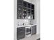 Stylish bar area featuring custom cabinetry, a wine fridge, and elegant countertops at 600 Quail Covey Road, Henderson, NV 89002