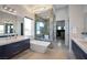 Elegant bathroom featuring a soaking tub, marble shower, dual vanities, and stylish lighting at 600 Quail Covey Road, Henderson, NV 89002