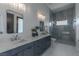 Modern bathroom features double vanity, sleek cabinetry, quartz countertop, and glass-enclosed tiled shower at 600 Quail Covey Road, Henderson, NV 89002