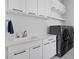 Functional laundry room with ample cabinet space, modern washer/dryer, and a sink at 600 Quail Covey Road, Henderson, NV 89002