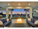 Inviting covered patio area with a fire pit, comfortable seating, and views of the beautifully landscaped backyard at 600 Quail Covey Road, Henderson, NV 89002