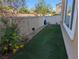 Backyard featuring artificial turf, vinyl fencing, and low-maintenance desert landscaping at 7057 Millers Run St, North Las Vegas, NV 89084