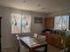 Dining area with tile flooring, a table with four chairs, and natural light from two windows at 7057 Millers Run St, North Las Vegas, NV 89084