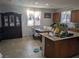 Bright kitchen featuring tile flooring, granite countertops, a kitchen island, and a dining area with white chairs at 7057 Millers Run St, North Las Vegas, NV 89084