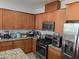 Kitchen featuring brown cabinets, stainless steel appliances, and granite countertops at 7057 Millers Run St, North Las Vegas, NV 89084