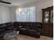 Comfortable living room showcases a large brown sectional sofa, glass coffee table and tile flooring at 7057 Millers Run St, North Las Vegas, NV 89084