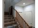 Carpeted staircase featuring wood railing and white doors at 7057 Millers Run St, North Las Vegas, NV 89084