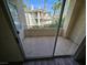 View from private balcony with neutral concrete floor, with palm trees and another building in the background at 7115 S Durango Dr # 208, Las Vegas, NV 89113