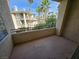 Private balcony with neutral concrete floor, palm trees and a building in the background on a bright day at 7115 S Durango Dr # 208, Las Vegas, NV 89113