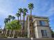 Beautiful condo building with desert landscaping and tall palm trees against a blue sky at 7115 S Durango Dr # 208, Las Vegas, NV 89113