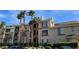 Multi-story apartment building with neutral stucco, dark trim, and palm tree landscaping at 7115 S Durango Dr # 208, Las Vegas, NV 89113