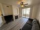 Comfortable living room featuring modern flooring, a ceiling fan, fireplace, and access to a private balcony at 7115 S Durango Dr # 208, Las Vegas, NV 89113