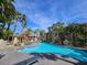 Inviting community pool surrounded by mature palm trees and lounge chairs at 7115 S Durango Dr # 208, Las Vegas, NV 89113