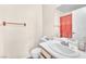A compact bathroom featuring a sink, toilet, mirror, and a red shower curtain at 719 Roberta Alecia Ave, North Las Vegas, NV 89031