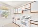 Bright kitchen with white cabinets and counters; open to the view outside the window at 719 Roberta Alecia Ave, North Las Vegas, NV 89031