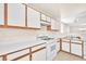 Bright kitchen with white cabinets, countertops, and appliances with a view to the living room at 719 Roberta Alecia Ave, North Las Vegas, NV 89031
