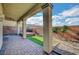 Covered brick patio with columns, landscaped planters, decorative brickwork and distant mountain views at 722 Chepstow Ave, Las Vegas, NV 89178