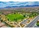 An aerial view of a neighborhood showcasing green spaces, parks, and mountain views at 7613 Pulpit Rock Ct, Las Vegas, NV 89166