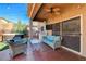 Relaxing covered patio with ceiling fan, outdoor seating, TV, and nearby hot tub and grill area at 7613 Pulpit Rock Ct, Las Vegas, NV 89166