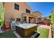 Beautiful backyard with a hot tub, outdoor kitchen, and covered patio with string lights at 7613 Pulpit Rock Ct, Las Vegas, NV 89166
