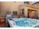 A luxurious backyard featuring a hot tub, a built-in grill, and a covered patio area at 7613 Pulpit Rock Ct, Las Vegas, NV 89166