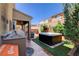 This backyard has an outdoor kitchen, covered patio, hot tub, and cozy lounge area at 7613 Pulpit Rock Ct, Las Vegas, NV 89166