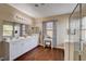 Bright bathroom features double sinks, vanity, walk-in shower, and wood flooring at 7613 Pulpit Rock Ct, Las Vegas, NV 89166