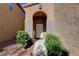 Charming front entrance with a covered porch, desert landscaping, and an arched entryway to the front door at 7613 Pulpit Rock Ct, Las Vegas, NV 89166