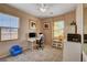 Comfortable home office with natural light, a modern desk setup, and a cozy blue chair at 7613 Pulpit Rock Ct, Las Vegas, NV 89166