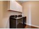Efficient laundry room with a modern washer and dryer set and upper cabinets for storage at 7613 Pulpit Rock Ct, Las Vegas, NV 89166