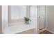 Bright bathroom featuring a garden tub with a shower, frosted windows, and a decorative plant at 7857 Midnight Ride St, Las Vegas, NV 89131