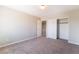 Empty bedroom with neutral walls, carpet, and closet with white sliding doors at 7857 Midnight Ride St, Las Vegas, NV 89131