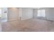 Spacious living room with neutral walls, plush carpet, and a large window offering natural light at 7857 Midnight Ride St, Las Vegas, NV 89131