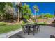 Manicured backyard with a seating area, green lawn, and lush landscaping at 8041 Villa Rosarito St, Las Vegas, NV 89131