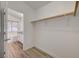 Walk-in closet with wood-look floors, an open rod for hanging clothes, and a doorway to the bathroom at 8041 Villa Rosarito St, Las Vegas, NV 89131