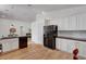 Spacious kitchen featuring white cabinets, black appliances, and wood-style flooring at 8041 Villa Rosarito St, Las Vegas, NV 89131