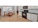 Clean kitchen featuring white cabinets, a black gas range, and a dining area at 8041 Villa Rosarito St, Las Vegas, NV 89131