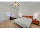Bright main bedroom with wood-look floors, ceiling fan, exercise machine, and a glimpse into the ensuite bathroom at 8041 Villa Rosarito St, Las Vegas, NV 89131
