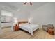 Bright main bedroom with wood-look floors, ceiling fan, and a glimpse into the ensuite bathroom at 8041 Villa Rosarito St, Las Vegas, NV 89131