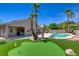 Resort-style backyard featuring a pool, putting green, and beautiful landscaping at 8080 Black Orchid Ave, Las Vegas, NV 89131