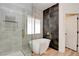 Elegant bathroom featuring a soaking tub, glass shower, and neutral tile at 8080 Black Orchid Ave, Las Vegas, NV 89131