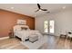 Modern bedroom with a ceiling fan, light wood floors, and a decorative accent wall at 8080 Black Orchid Ave, Las Vegas, NV 89131