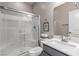 Bathroom showcasing a vanity sink with grey cabinetry and a glass enclosed shower with white tile at 813 Bluebird Hill Ave, North Las Vegas, NV 89084