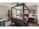 Beautiful bedroom with a gray four-poster bed, a nightstand, a dresser, and a window with natural light at 813 Bluebird Hill Ave, North Las Vegas, NV 89084