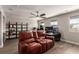 Spacious living room with dark wood floors, ceiling fan, and a brown leather reclining sofa with built-in cup holders at 813 Bluebird Hill Ave, North Las Vegas, NV 89084