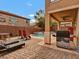 Backyard showcasing a pool, covered patio, and outdoor kitchen area with grill at 8267 Campbell Springs Ave, Las Vegas, NV 89178