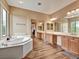 Bright bathroom featuring double sinks, bathtub and sliding mirrored doors at 8267 Campbell Springs Ave, Las Vegas, NV 89178