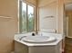 Bathroom showcasing a corner bathtub with a bright window at 8267 Campbell Springs Ave, Las Vegas, NV 89178