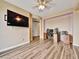 Spacious bedroom featuring a dedicated desk area with modern wood flooring and large television at 8267 Campbell Springs Ave, Las Vegas, NV 89178